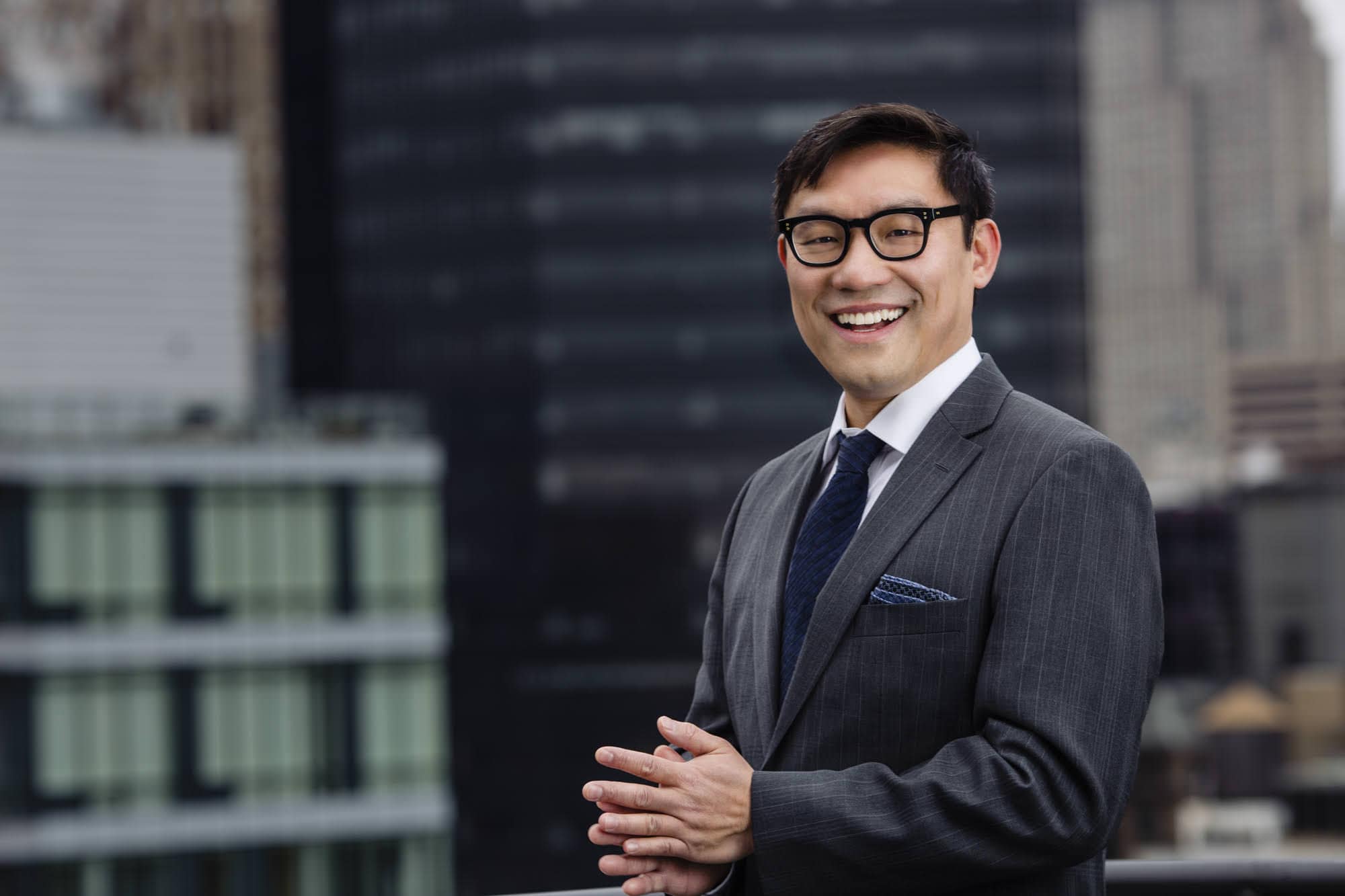 Outdoor corporate headshot in New York City, cityscape background.